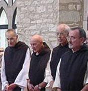 Monks pray as the body of their dead brother is brought into the church