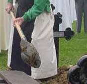 A monk of New Melleray takes his turn at filling in the grave of his brother